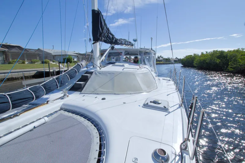 Scout Yacht Photos Pics Sailing on a 1996 Manta 40 catamaran in a sunny canal setting.