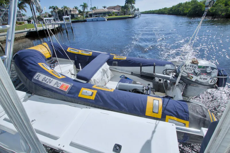 Scout Yacht Photos Pics Inflatable boat on a 1996 Manta 40 yacht, docked by a scenic waterway.