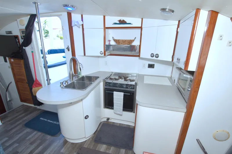 Scout Yacht Photos Pics Compact kitchen in a 1996 Manta 40 yacht with modern amenities and wood accents.