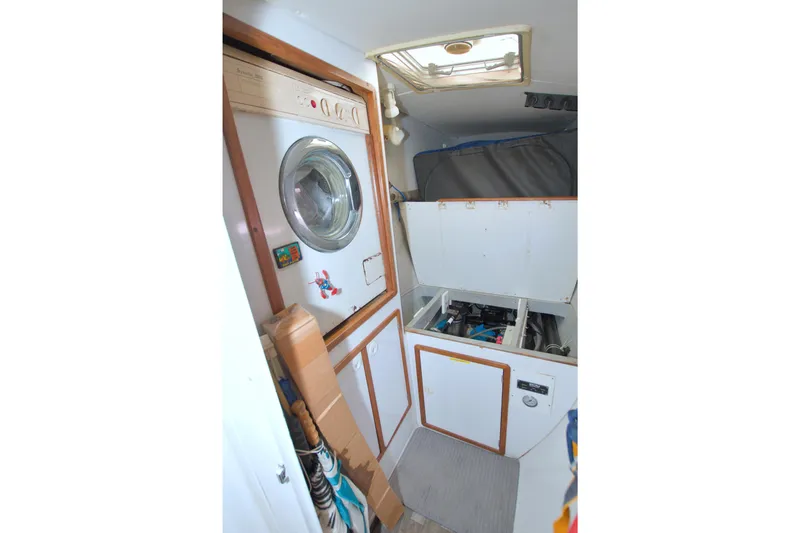Scout Yacht Photos Pics Laundry area inside a 1996 Manta 40 yacht, featuring a washing machine and storage compartments.