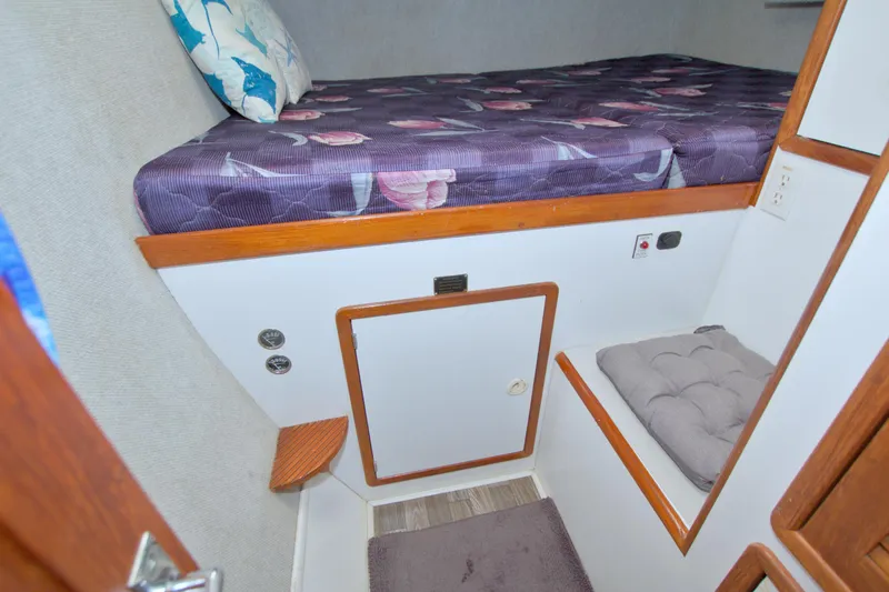 Scout Yacht Photos Pics Cozy cabin interior of 1996 Manta 40 sailboat with purple bedding and wooden accents.