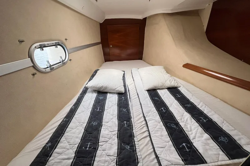 Searenity Yacht Photos Pics Cabin interior of 2005 Fountaine Pajot LAVEZZI 40 catamaran with nautical-themed bedding.