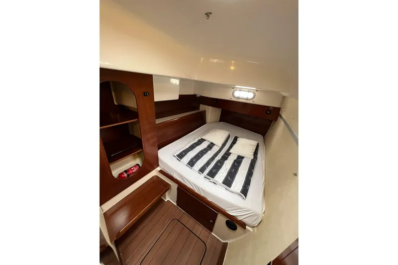 Searenity Yacht Photos Pics Cozy cabin interior of 2005 Fountaine Pajot LAVEZZI 40 catamaran with bed and wooden shelves.