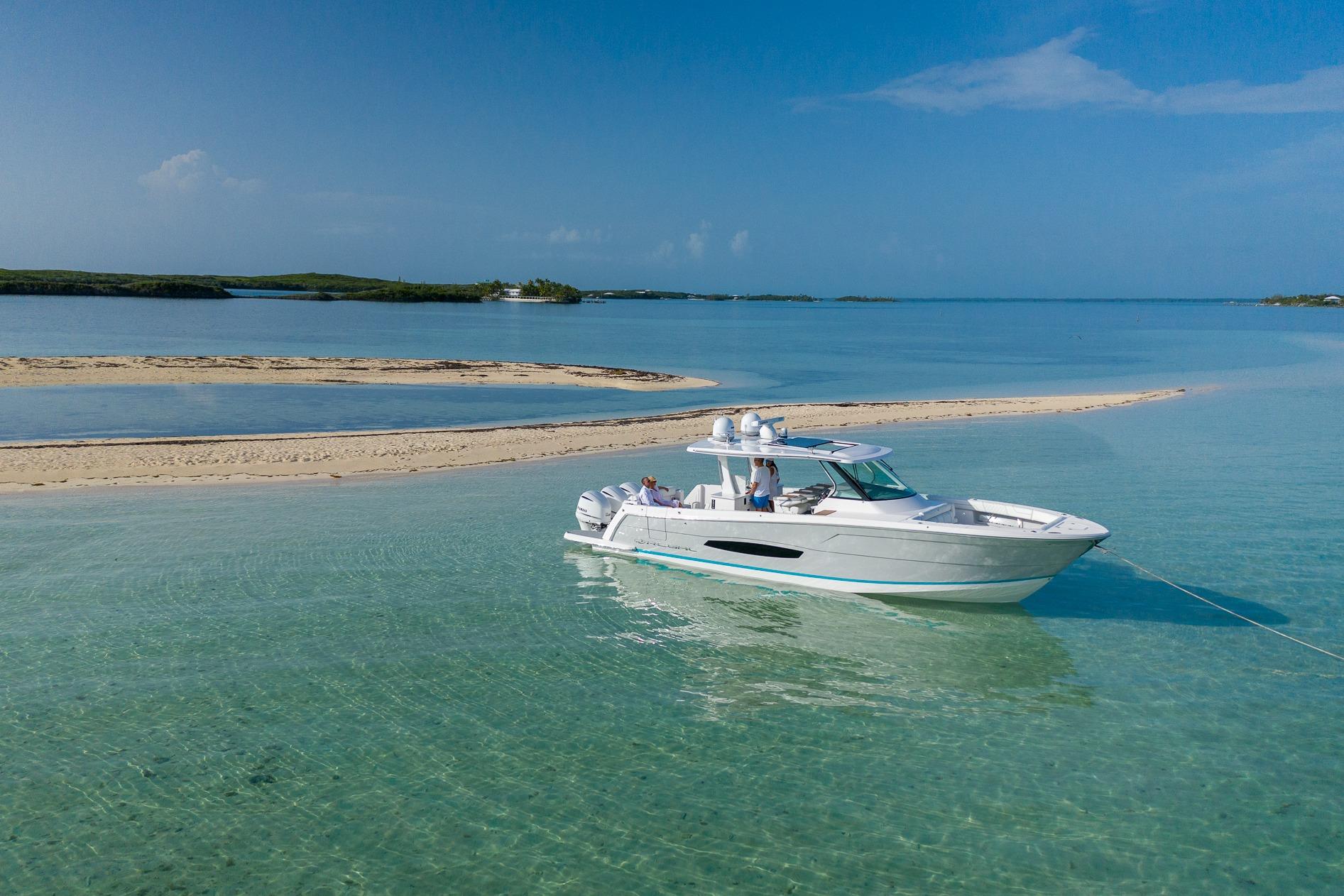 2026 Regal 38 SAV boat anchored in clear turquoise waters near a sandy island.