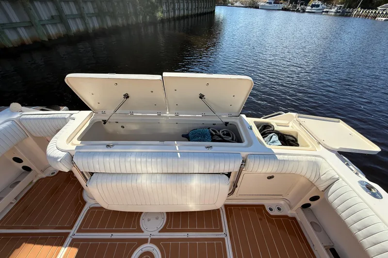 Yacht Photos Pics 2005 Grady-White Express 330 boat with open storage compartments on deck by the water.