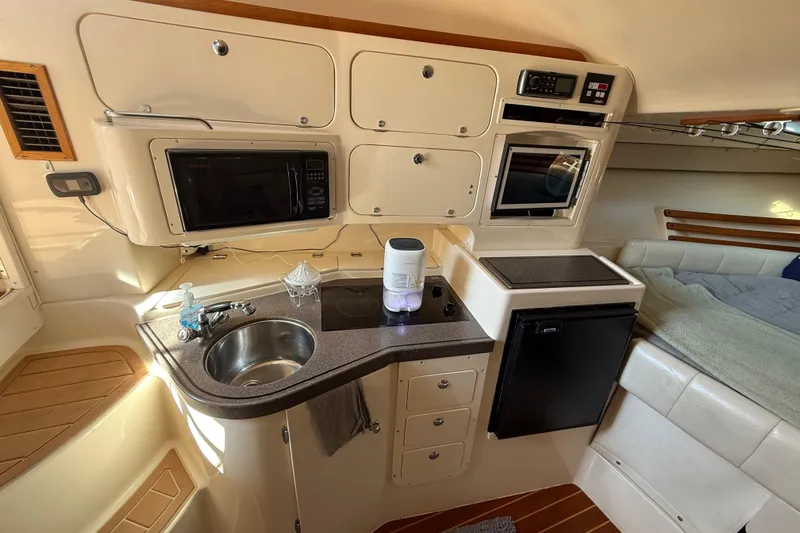  Yacht Photos Pics 2005 Grady-White Express 330 cabin with kitchenette, sink, microwave, and compact fridge.