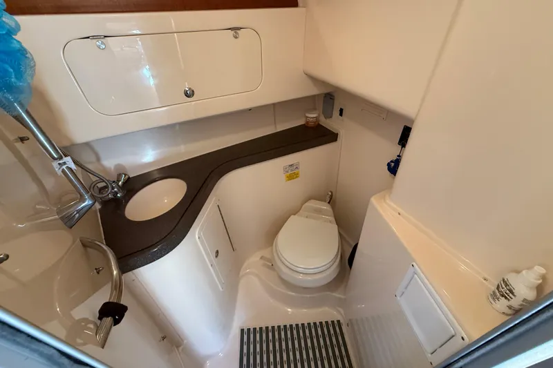  Yacht Photos Pics Compact bathroom in 2005 Grady-White Express 330 boat, featuring sink, toilet, and storage.