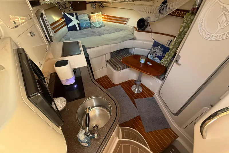  Yacht Photos Pics 2005 Grady-White Express 330 cabin interior with kitchenette, seating, and cozy sleeping area.
