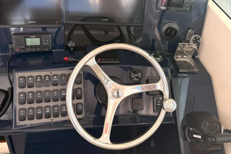  Yacht Photos Pics Control panel of a 2013 Pursuit 365i Sport Coupe with steering wheel and navigation equipment.