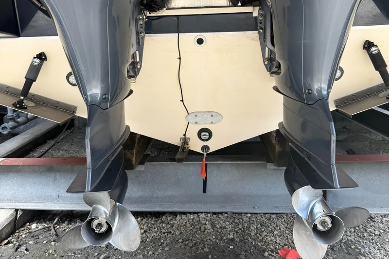  Yacht Photos Pics Twin outboard motors on a 2013 Pursuit 365i Sport Coupe boat, docked on gravel.