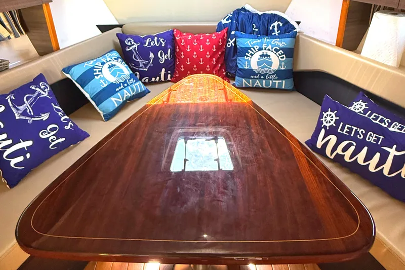  Yacht Photos Pics Interior of 2013 Pursuit 365i Sport Coupe with nautical-themed pillows and wooden table.
