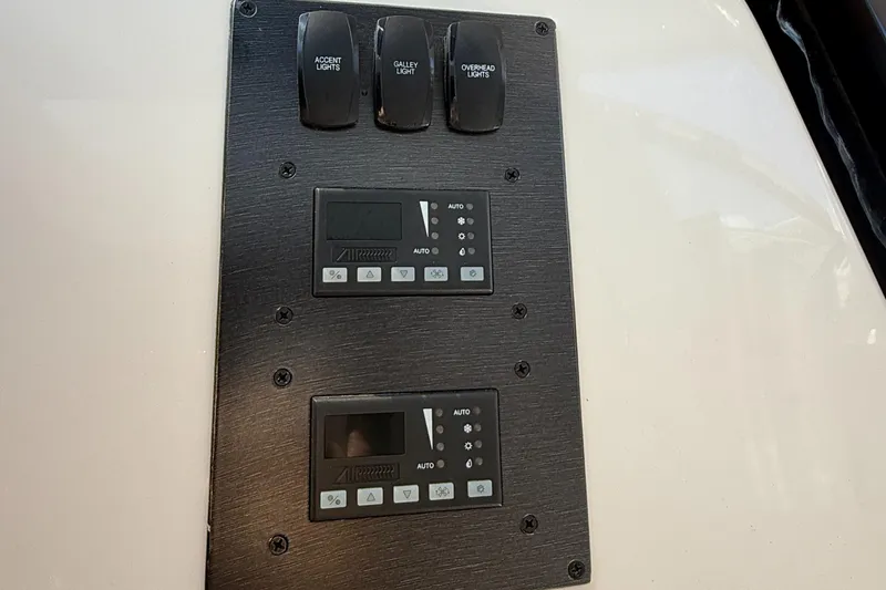  Yacht Photos Pics Control panel of a 2013 Pursuit 365i Sport Coupe with light switches and digital displays.