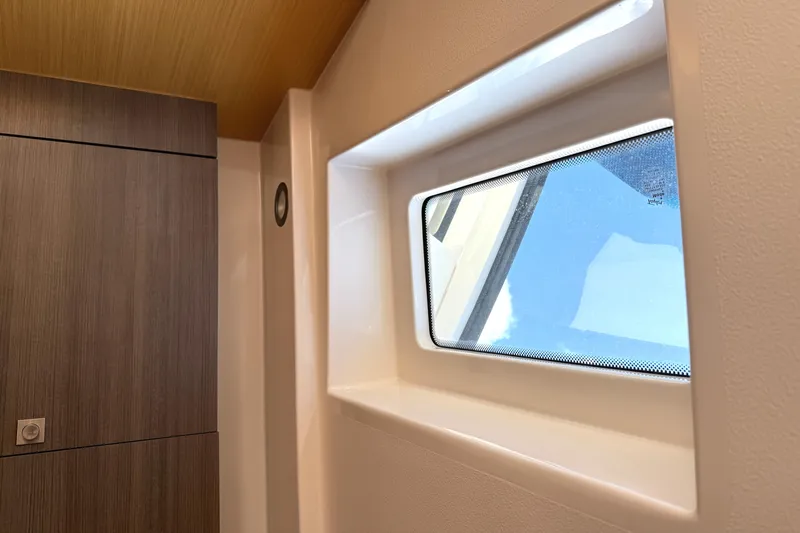  Yacht Photos Pics Interior view of 2013 Pursuit 365i Sport Coupe, featuring a window and wooden paneling.