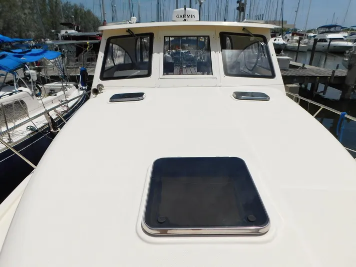 Calm Yacht Photos Pics 2005 Mainship 34 Rum Runner boat docked at marina, front deck view.