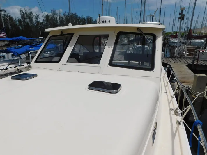 Calm Yacht Photos Pics 2005 Mainship 34 Rum Runner docked, featuring a Garmin navigation system.
