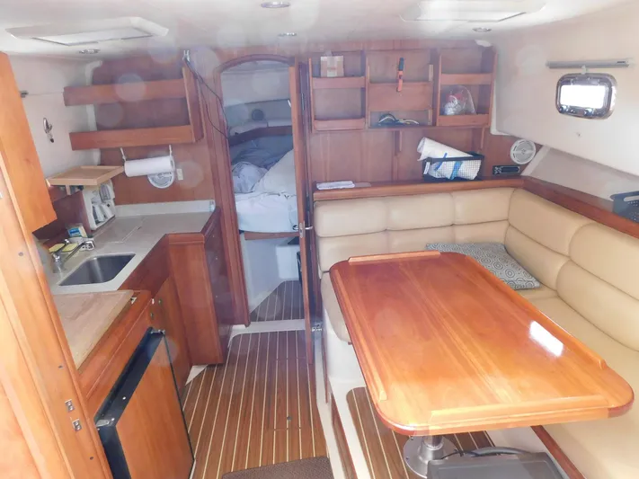 Calm Yacht Photos Pics 2005 Mainship 34 Rum Runner interior with wood finishes, kitchenette, and dining area.