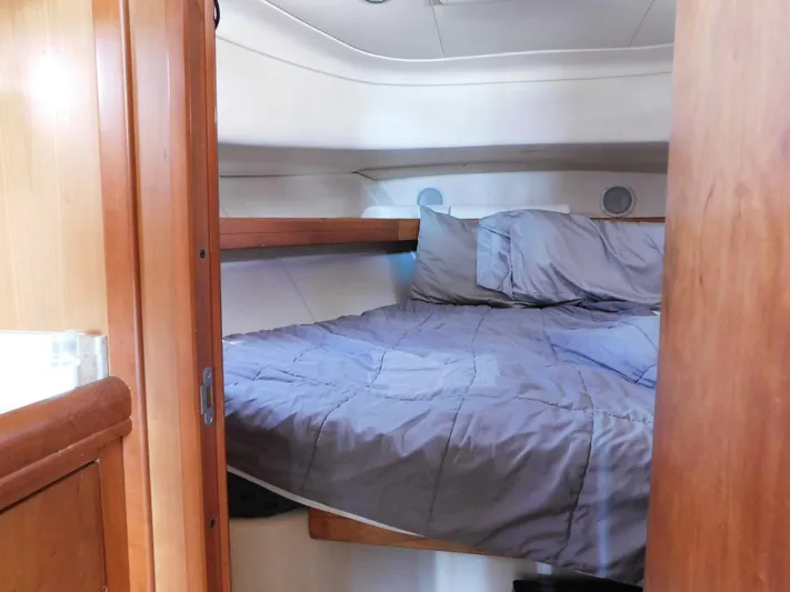 Calm Yacht Photos Pics 2005 Mainship 34 Rum Runner cabin with cozy bed and wooden interior.