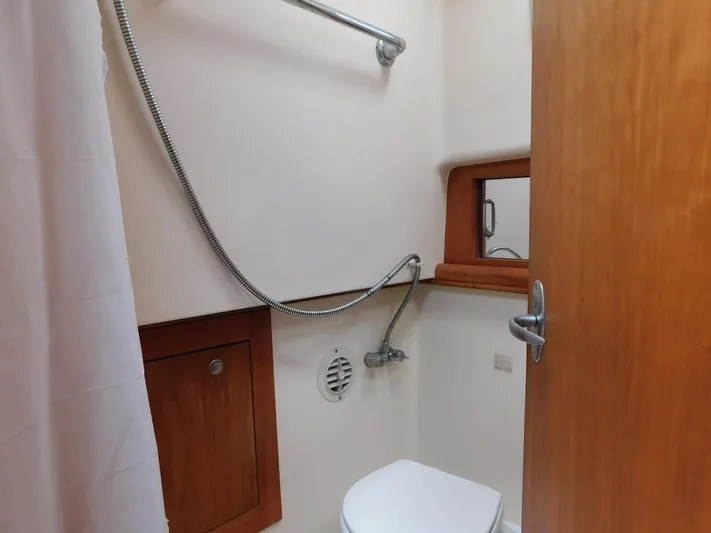 Calm Yacht Photos Pics 2005 Mainship 34 Rum Runner bathroom with shower, toilet, and wooden cabinetry.