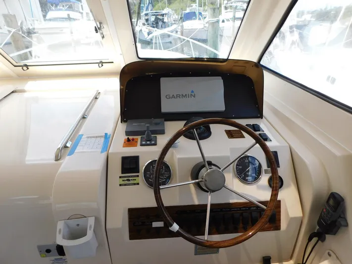 Calm Yacht Photos Pics 2005 Mainship 34 Rum Runner helm with Garmin navigation system and classic steering wheel.