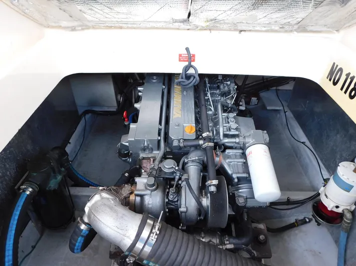 Calm Yacht Photos Pics Engine compartment of a 2005 Mainship 34 Rum Runner boat, showcasing mechanical components.