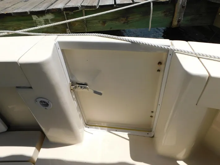 Calm Yacht Photos Pics 2005 Mainship 34 Rum Runner boat deck with storage compartment and dock rope.