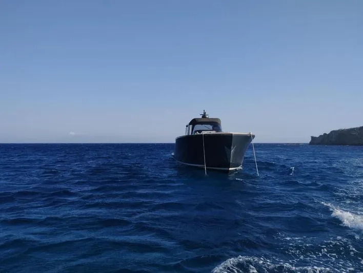  Yacht Photos Pics A 2016 Alen 55 boat anchored on a calm blue sea under a clear sky.