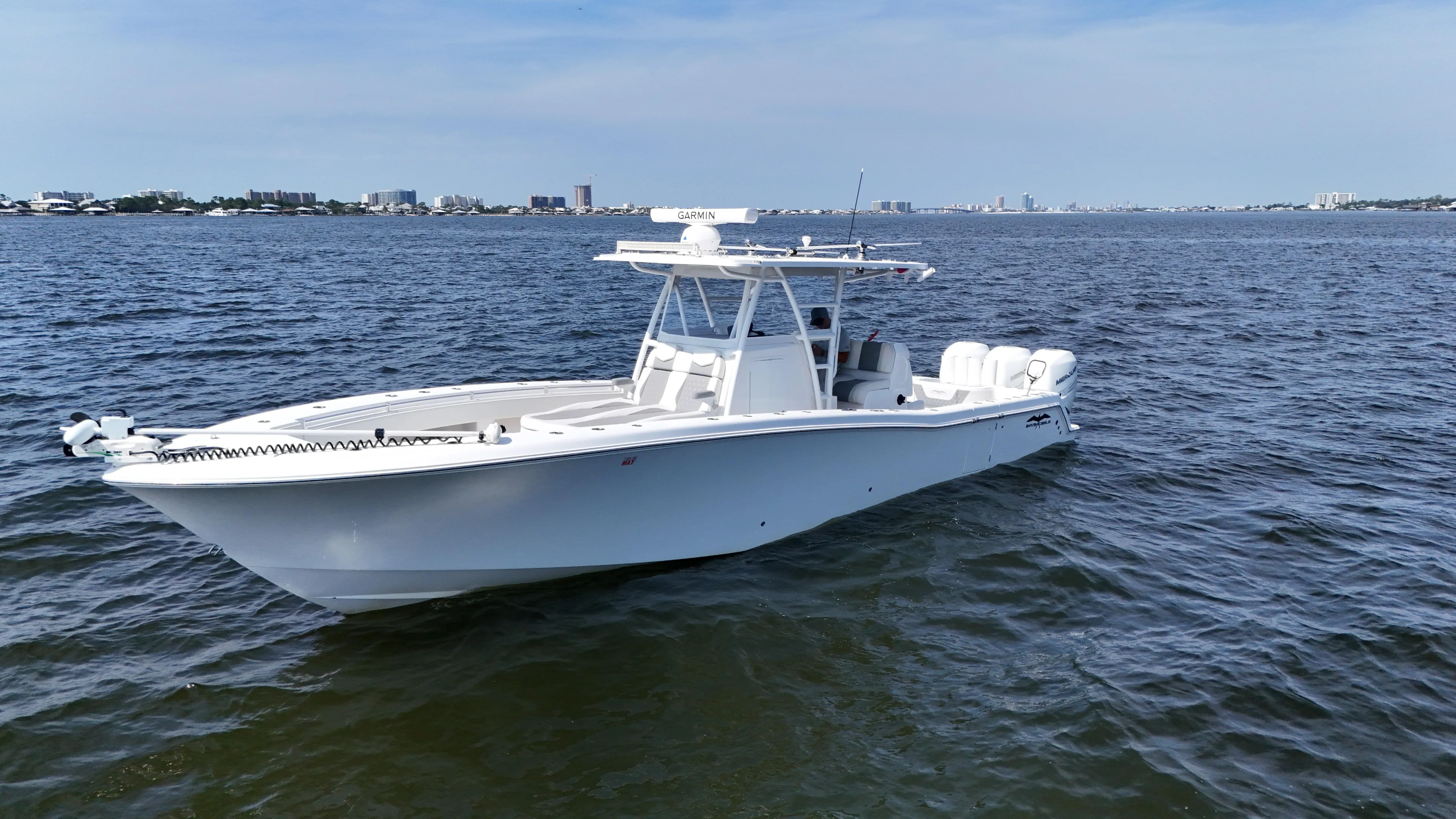  Yacht Photos Pics 2022 Invincible 36 Open Fisherman boat on calm waters, city skyline in background.