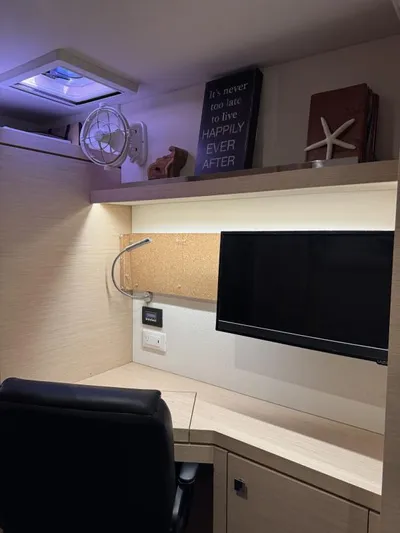The Flying Tortuga Yacht Photos Pics Compact workspace on 2018 Fountaine Pajot Lucia 40 yacht with desk, chair, and monitor.