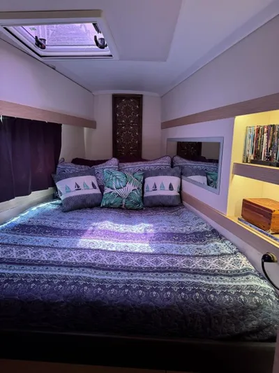 The Flying Tortuga Yacht Photos Pics Cozy bedroom in 2018 Fountaine Pajot Lucia 40 catamaran with decorative pillows and books.