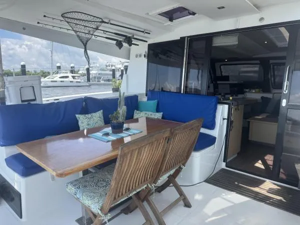 The Flying Tortuga Yacht Photos Pics 2018 Fountaine Pajot Lucia 40 yacht with outdoor dining area and blue seating.