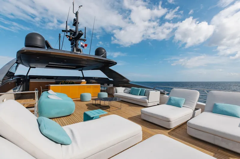 Ambar Yacht Photos Pics Luxurious Sanlorenzo SLA120A yacht deck with modern seating, ocean view, and clear blue sky.
