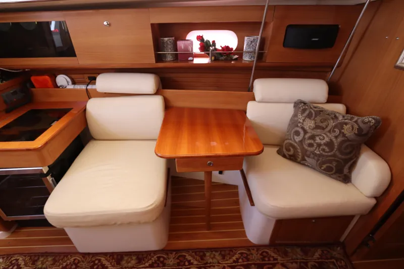  Yacht Photos Pics Cozy interior of 2011 Catalina 355 sailboat with wooden table and cushioned seating.