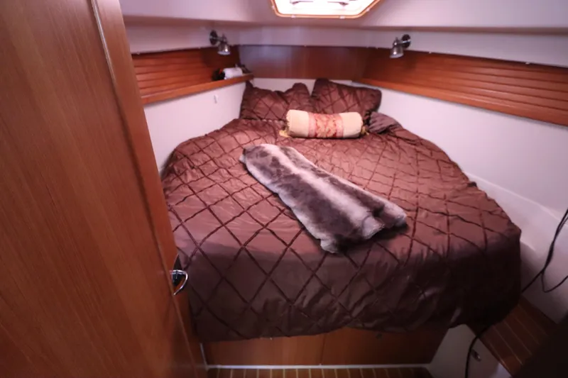  Yacht Photos Pics Cozy cabin interior of 2011 Catalina 355 sailboat with plush bedding and wood accents.