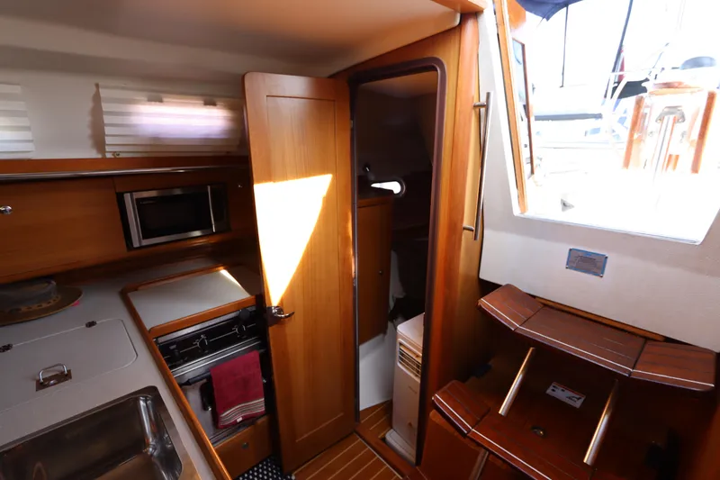  Yacht Photos Pics Interior of 2011 Catalina 355 sailboat with kitchen and wooden cabinetry.