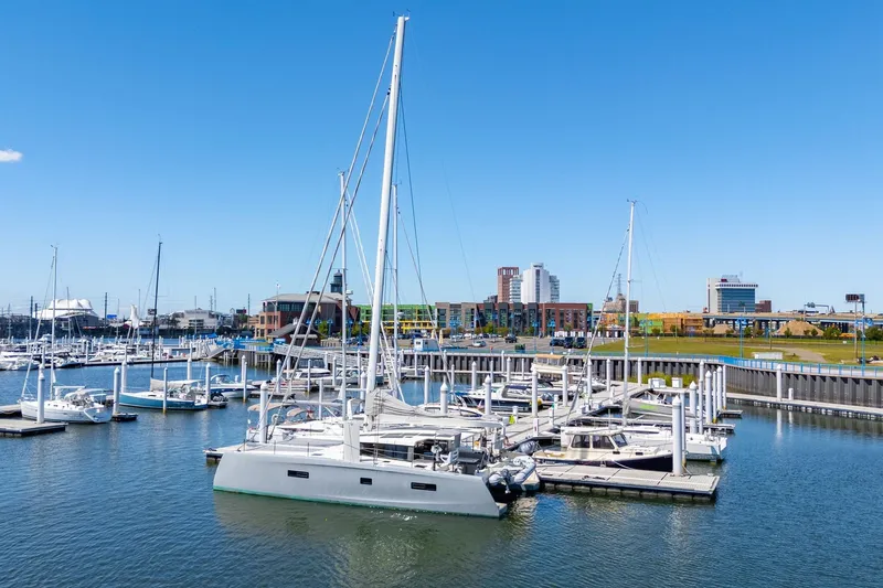 Navitas Yacht Photos Pics 2019 Itacatamarans 14.99 docked in a marina with cityscape background.