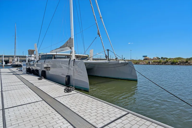 Navitas Yacht Photos Pics 2019 Itacatamarans 14.99 catamaran docked at marina under clear blue sky.