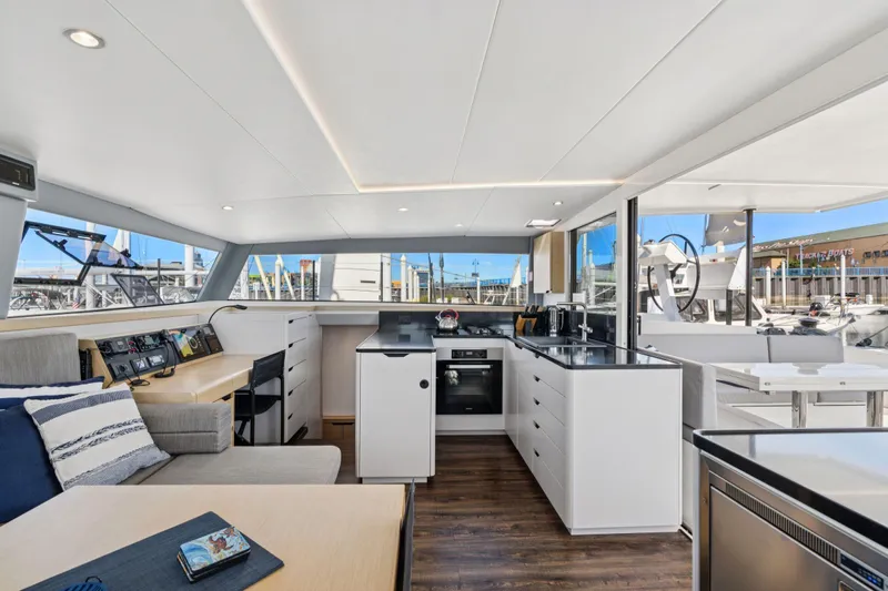 Navitas Yacht Photos Pics Luxurious interior of 2019 Itacatamarans 14.99, featuring modern kitchen and seating area.