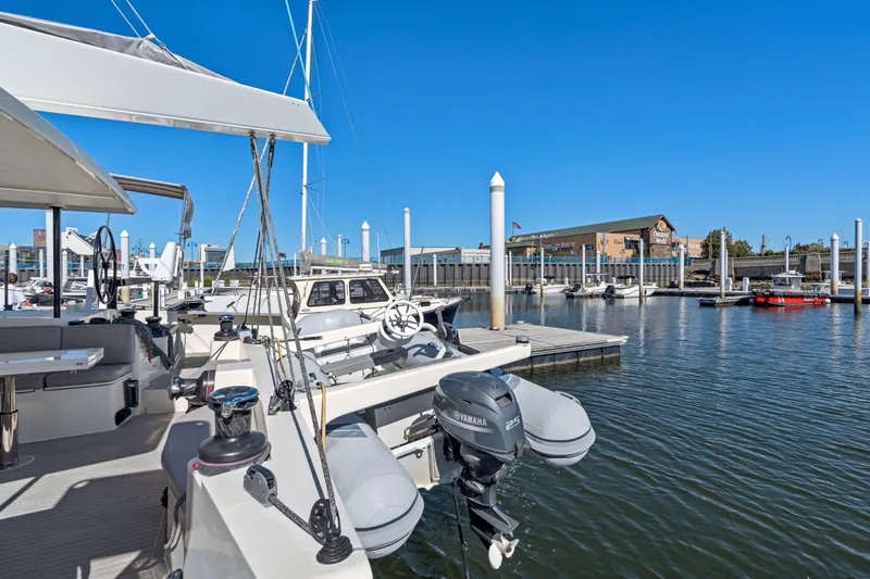 Navitas Yacht Photos Pics 2019 Itacatamarans 14.99 docked at marina with clear blue sky.