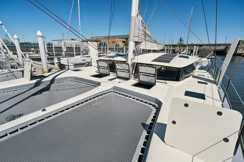 Navitas Yacht Photos Pics 2019 Itacatamarans 14.99 catamaran docked, showcasing deck and solar panels under clear blue sky.