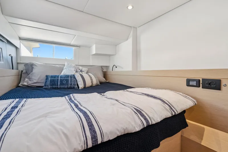 Navitas Yacht Photos Pics Cozy bedroom interior of 2019 Itacatamarans 14.99 with nautical-themed bedding.