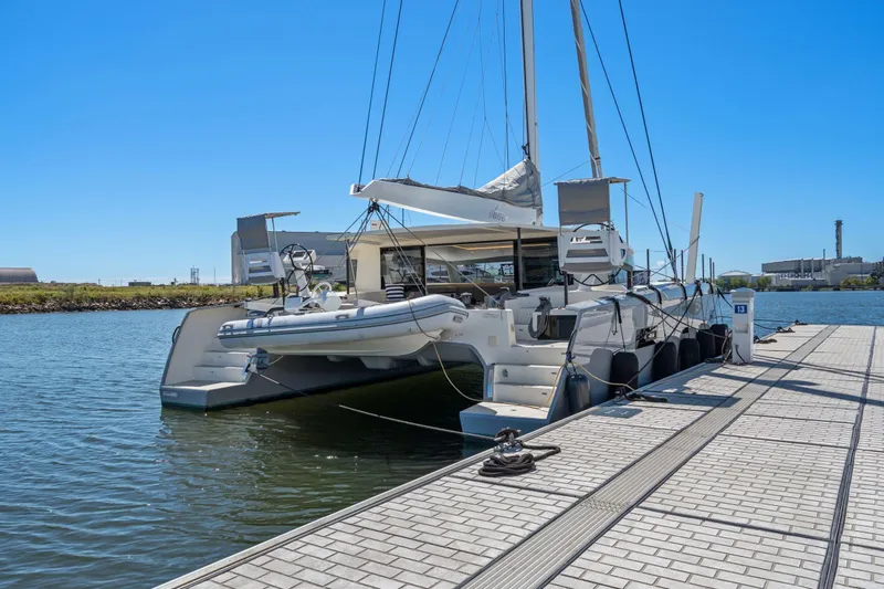 Navitas Yacht Photos Pics 2019 Itacatamarans 14.99 catamaran docked at marina under clear blue sky.