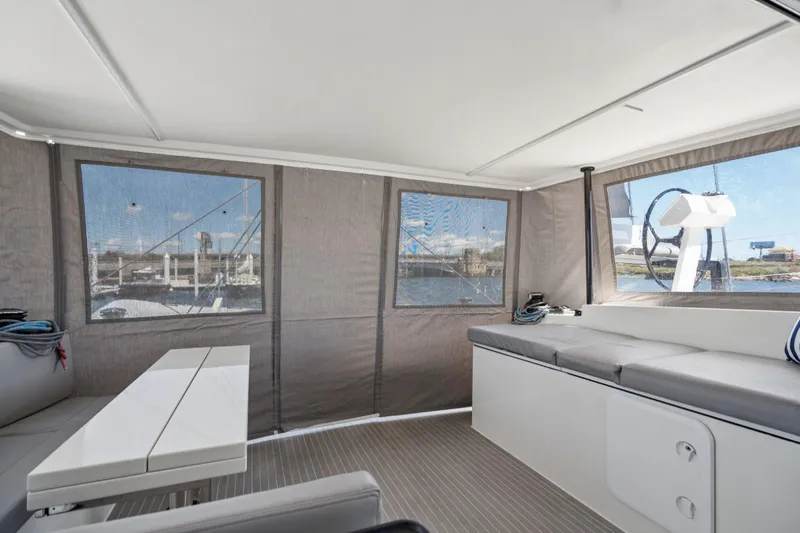 Navitas Yacht Photos Pics Interior of 2019 Itacatamarans 14.99, featuring seating and windows with marina view.