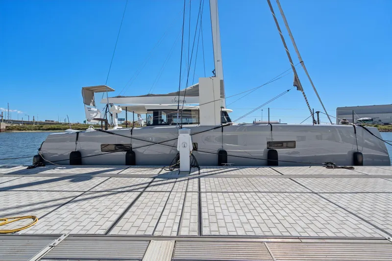 Navitas Yacht Photos Pics 2019 Itacatamarans 14.99 catamaran docked at a marina under clear blue skies.