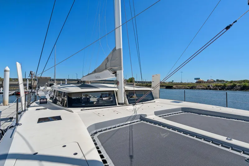 Navitas Yacht Photos Pics 2019 Itacatamarans 14.99 catamaran docked by a river under clear blue sky.