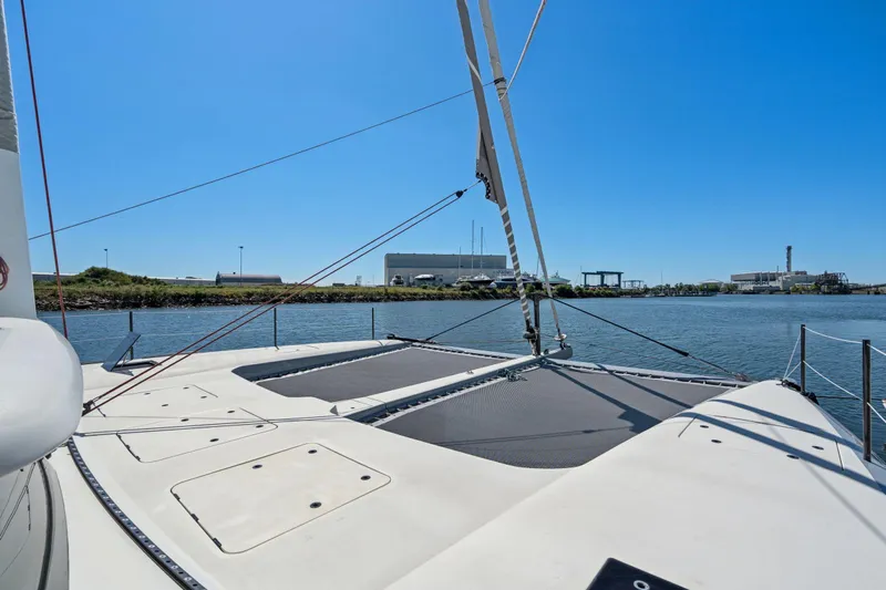 Navitas Yacht Photos Pics 2019 Itacatamarans 14.99 catamaran on calm water, clear sky, industrial background.