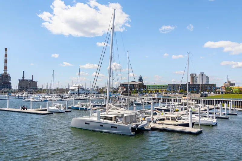 Navitas Yacht Photos Pics 2019 Itacatamarans 14.99 docked in a bustling marina under a clear blue sky.