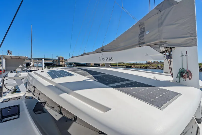 Navitas Yacht Photos Pics 2019 Itacatamarans 14.99 catamaran with solar panels and sails, docked under clear blue sky.