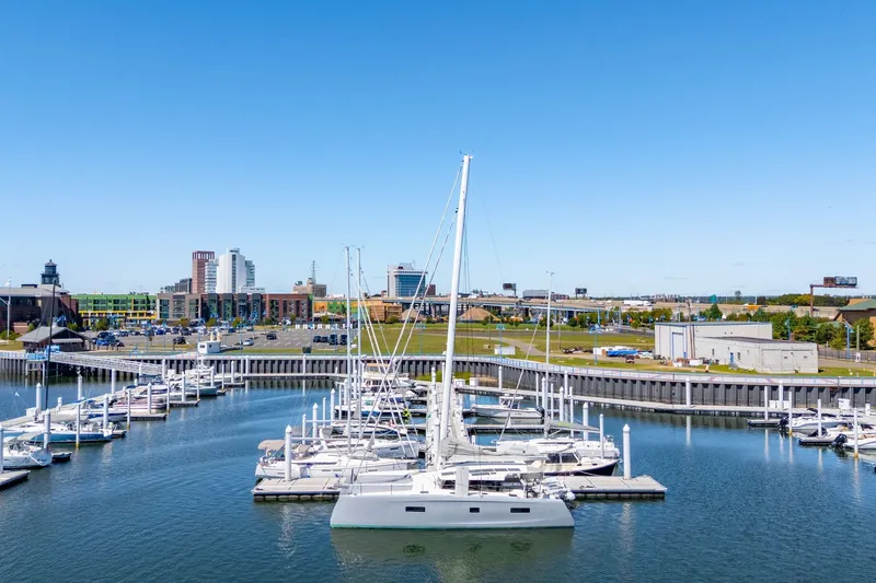 Navitas Yacht Photos Pics Modern Itacatamarans 14.99 (2019) docked in a scenic marina with cityscape background.