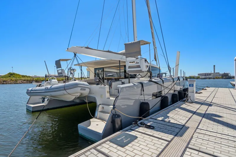 Navitas Yacht Photos Pics 2019 Itacatamarans 14.99 catamaran docked at marina under clear blue sky.