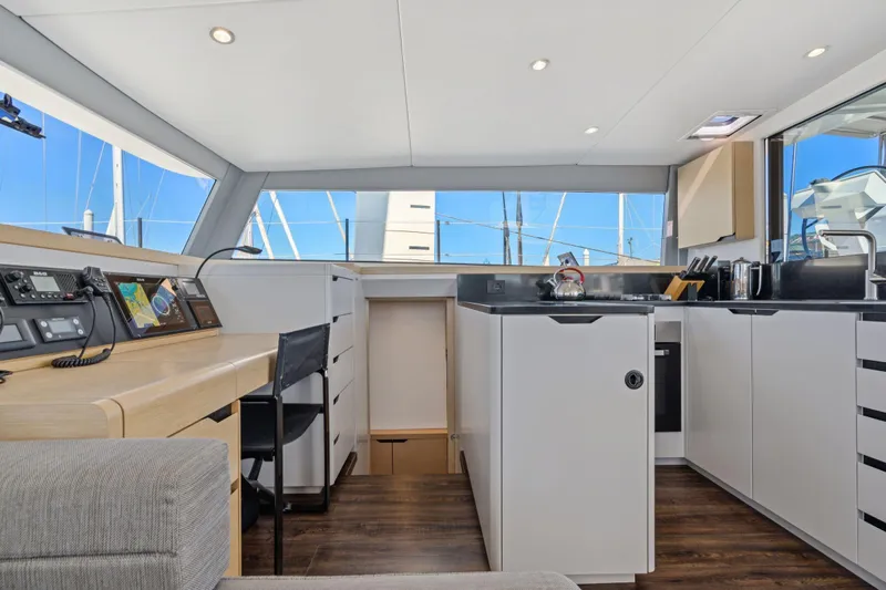 Navitas Yacht Photos Pics Modern interior of 2019 Itacatamarans 14.99 with sleek kitchen and navigation area.